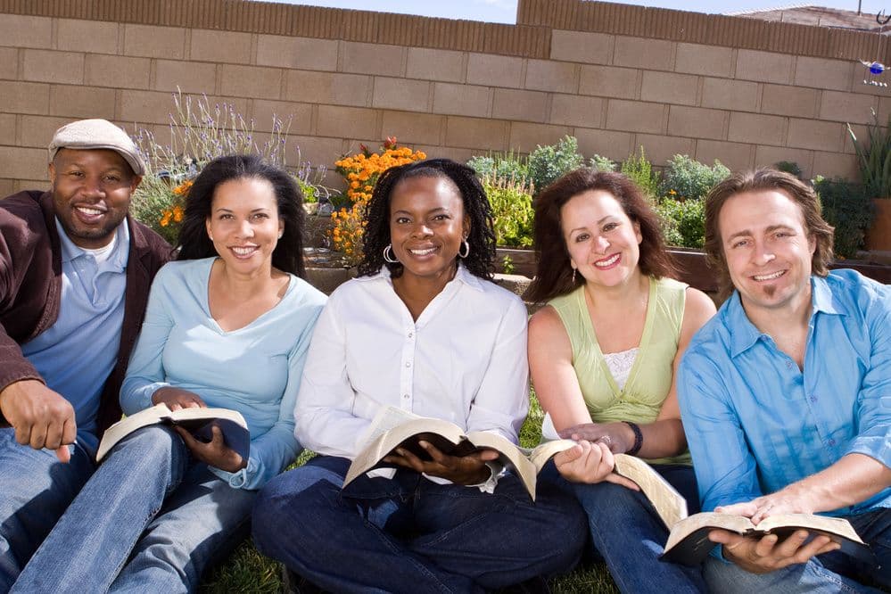 Small group gathered outdoors with Bibles